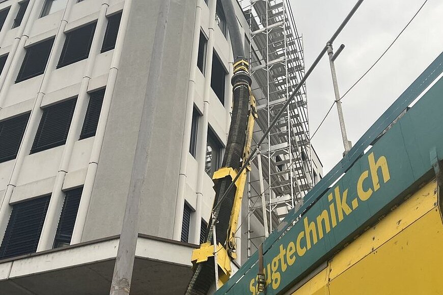 Saugbagger während dem Absaugen vor dem Gebäude