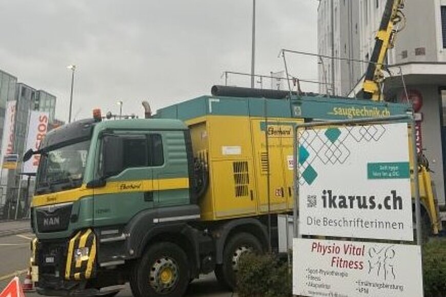 Saugbagger installiert vor Gebäude während dem Saugen