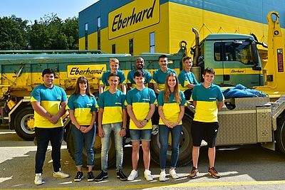 Die Lernenden der Eberhard Unternehmungen posieren als Gruppe vor einem Lastwagen.